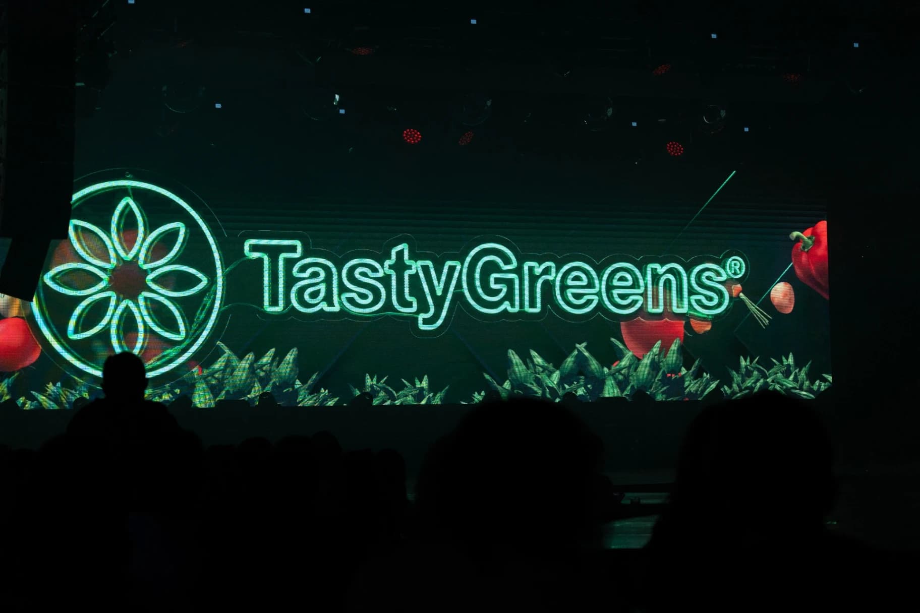 Escenario de Mr Model México con el logo neón de Tasty Greens