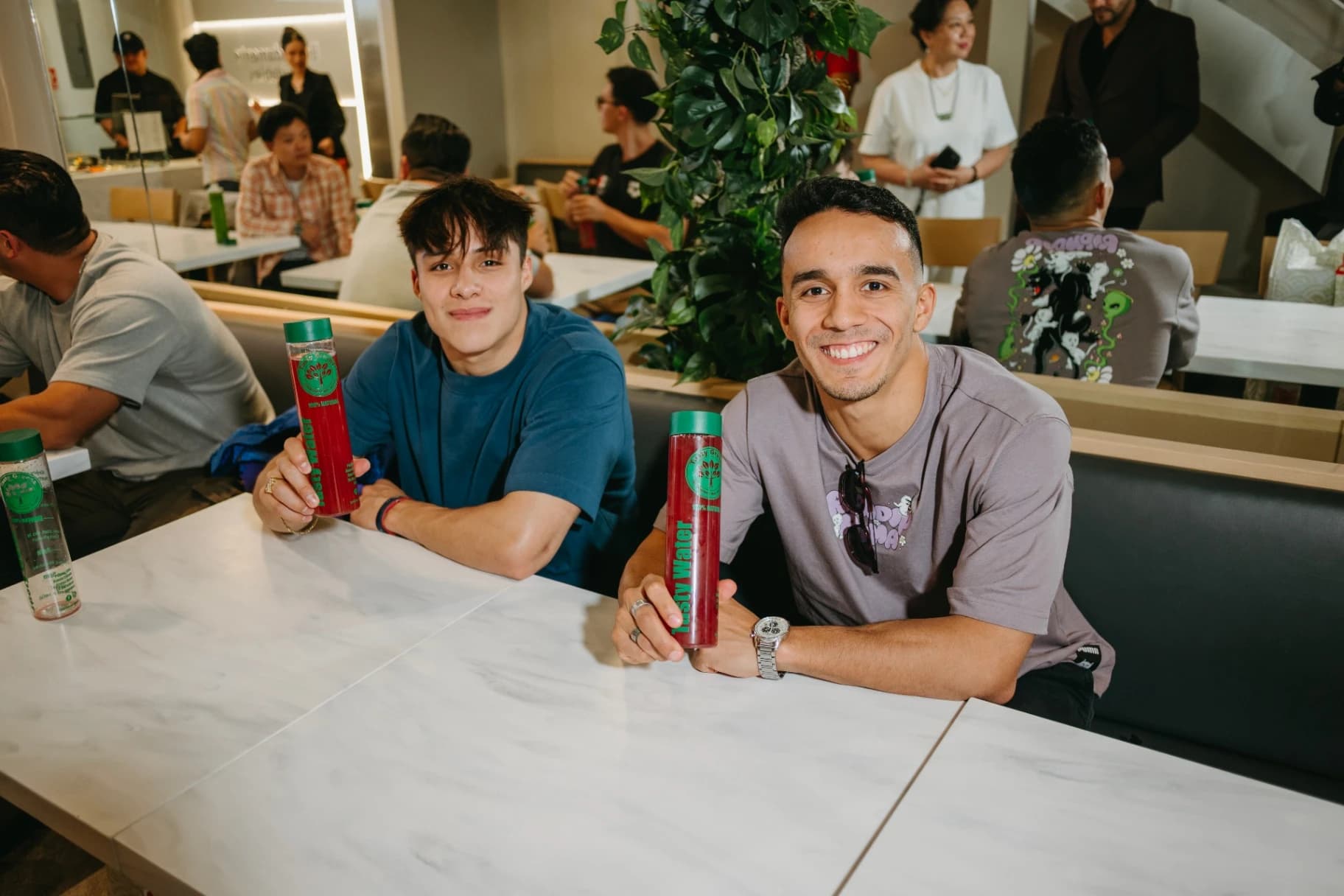 Osmar Olvera y Juan Manuel Celaya con jugos verdes Tasty Greens en la mesa