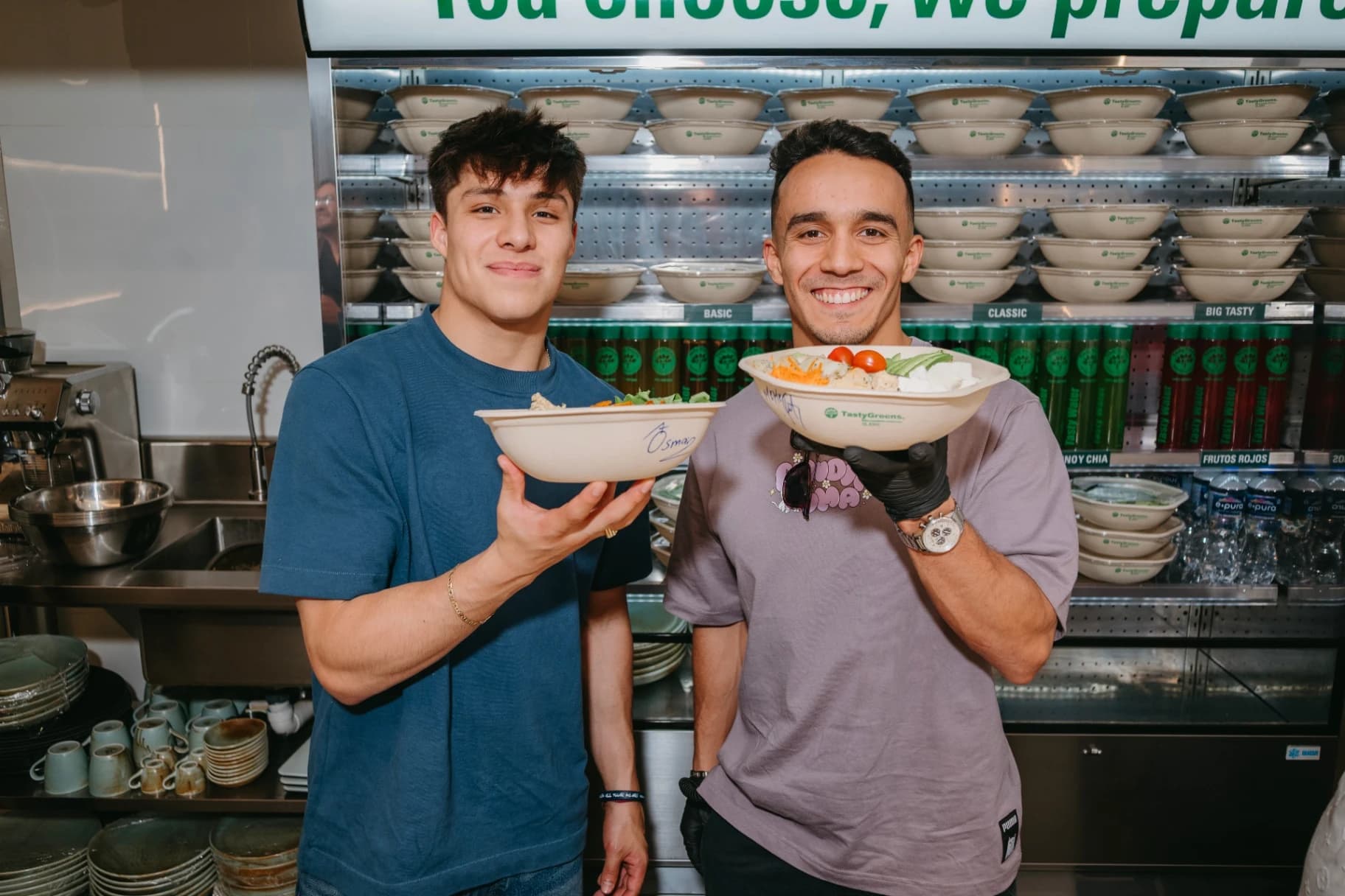 Osmar Olvera y Juan Manuel Celaya con ensaladas Tasty Greens en la barra