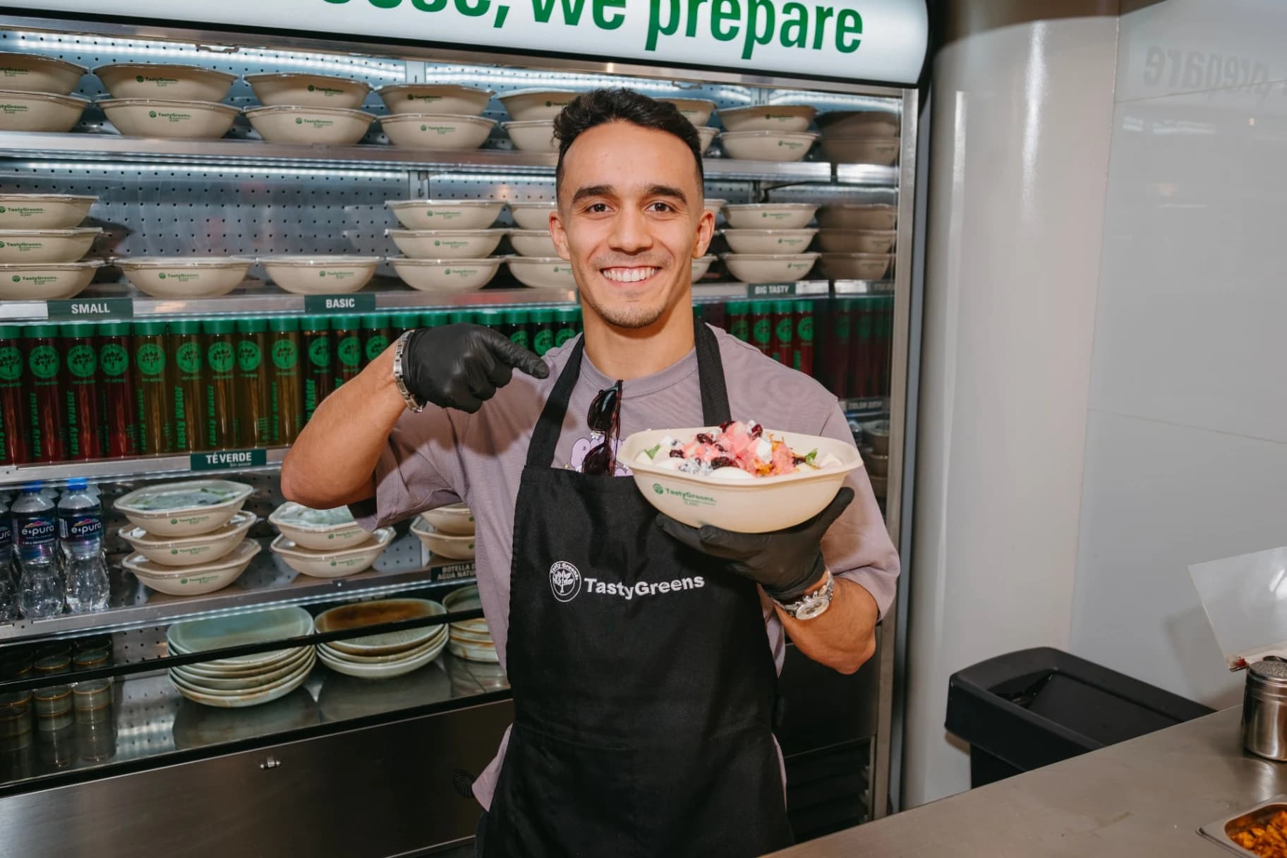Juan Manuel Celaya con una ensalada Tasty Greens frente al mostrador