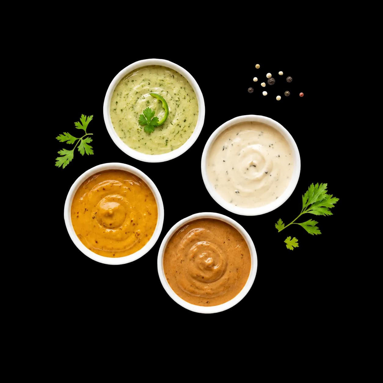 Cuatro aderezos Tasty servidos en porciones individuales con hierbas y especias frescas