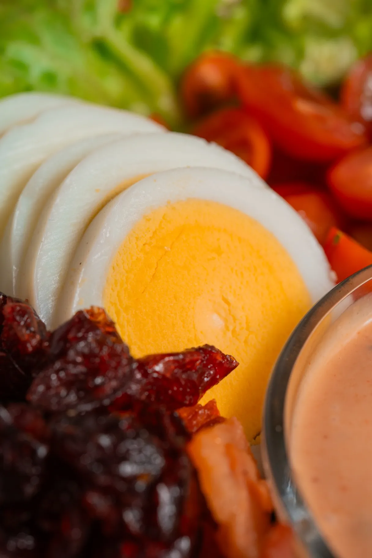Primer plano de una ensalada Tasty Greens con huevo cocido en rodajas, jitomate cherry y betabel