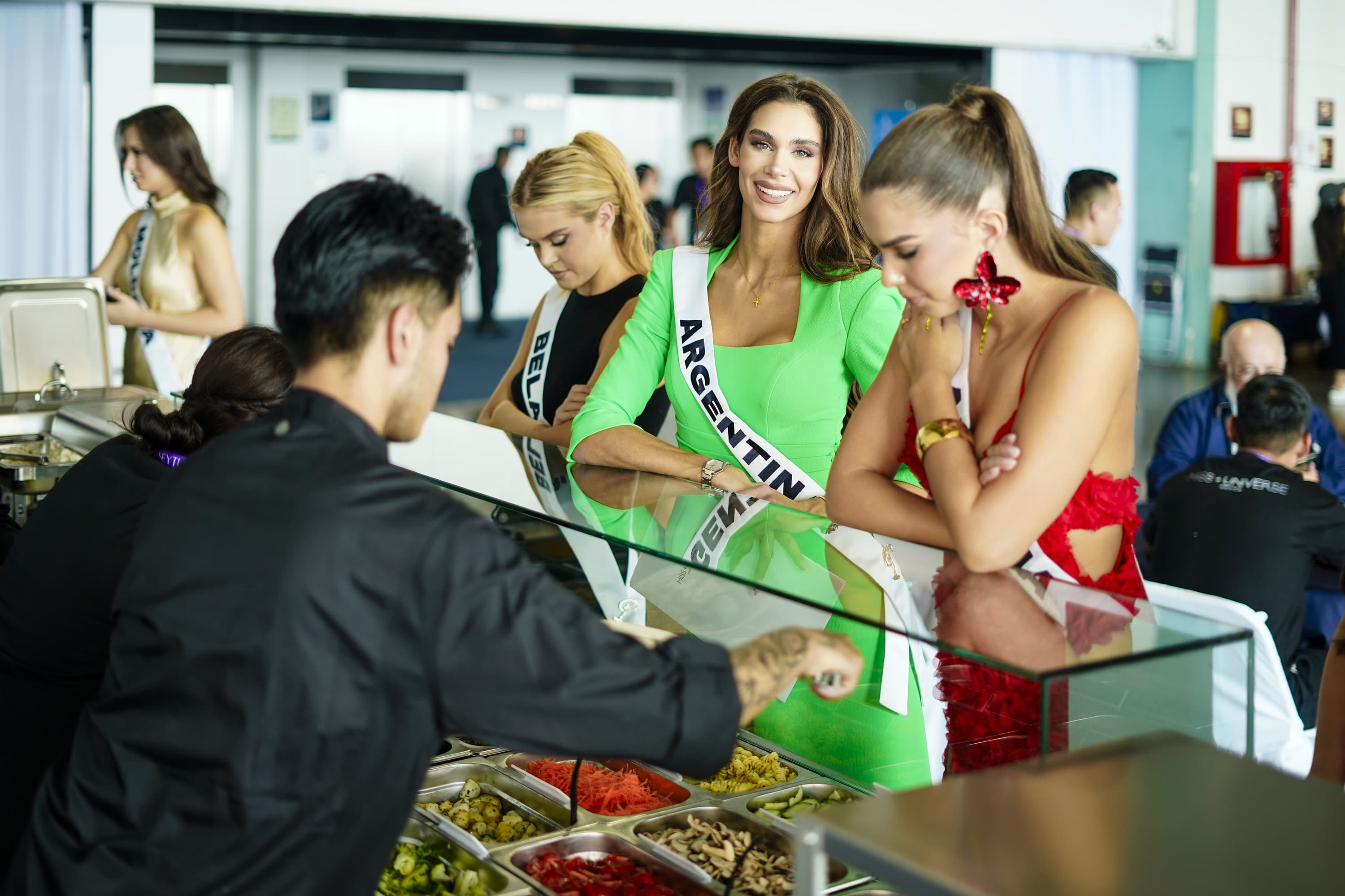 Candidatas de Miss Universe sirviéndose en la barra de ensaladas Tasty Greens